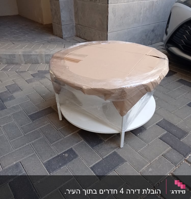 שולחן עגול עטוף בניילון וקרטון למעבר דירה